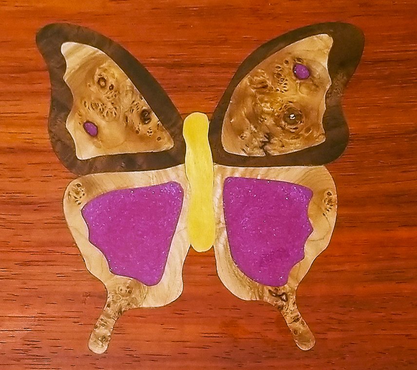 Image of a FlutterBy decorative inlay built with epoxy and glitter for the wings